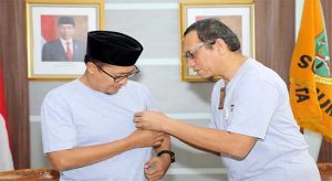 Kepala Kantor KPP Pratama Sukabumi (kanan) menyematkan pin ke Walikota Sukabumi.