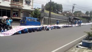 SPN Cianjur Bentangkan Kain Ratusan Meter di Jalur Protokol Cipanas