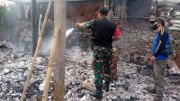 PENDINGINAN : Salah seorang petugas dari Babinsa saat melakukan pendinginan terhadap rumah yang terbakar di Kampung Nangela RT (05/ 08) Desa/Kecamatan Jampangtengah