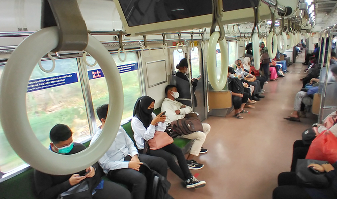 Penumpang duduk tanpa berjarak di dalam KRL Commuter