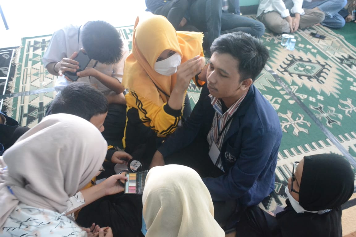 Salah seorang Mahasiswa IPB saat di make Up anak-anak Disabilitas Tuna Netra
