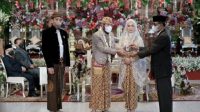 Ketua MK Anwar Usman menunjukkan buku nikah usai resmi menjadi suami adik Jokowi