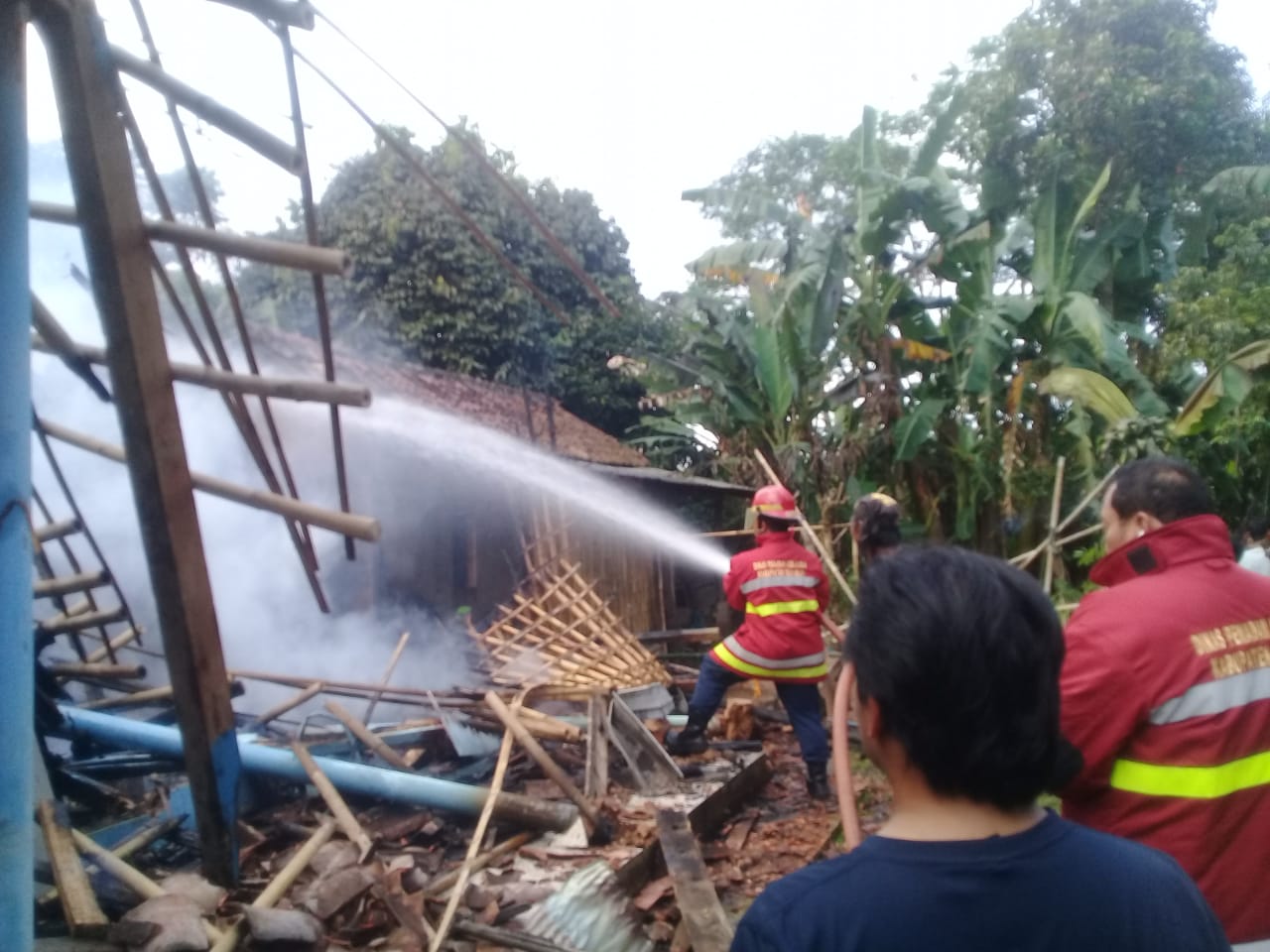 Sejumlah petugas damkar dibantu warga