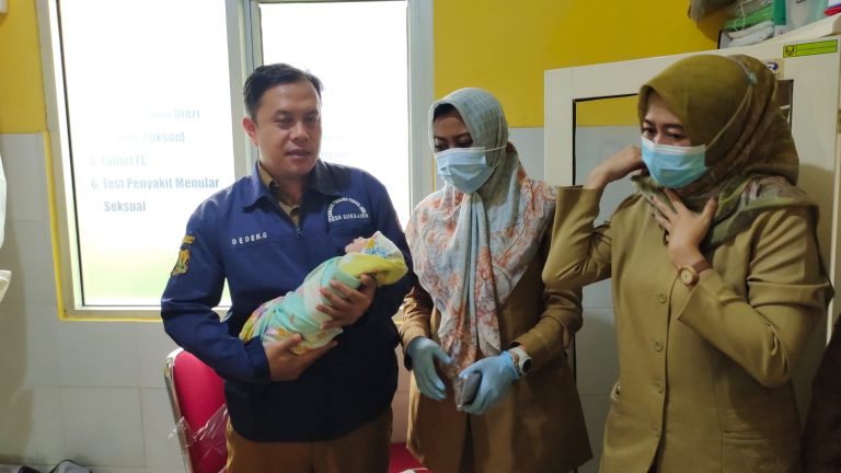 Kepala Desa Sukajaya, Deden Gunaefi saat mengevakuasi bayi