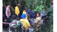 Warga bersama anggota TNI berupaya mengevakuasi korban yang masih terjepit di