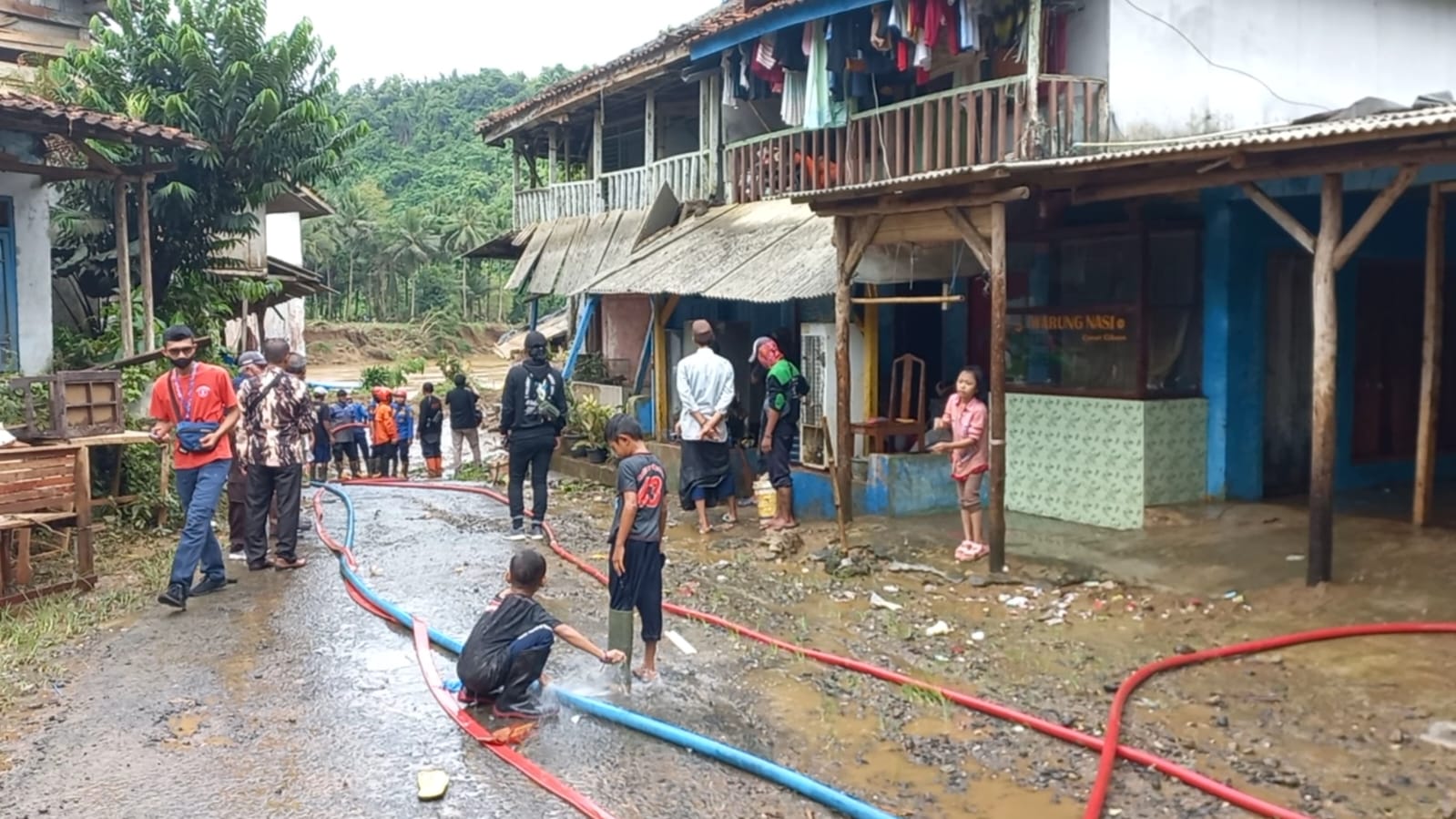 Suasana saat petugas membersihkan material lumpur yang menutup jalan di kampung Cinitih, desa Cibitung,