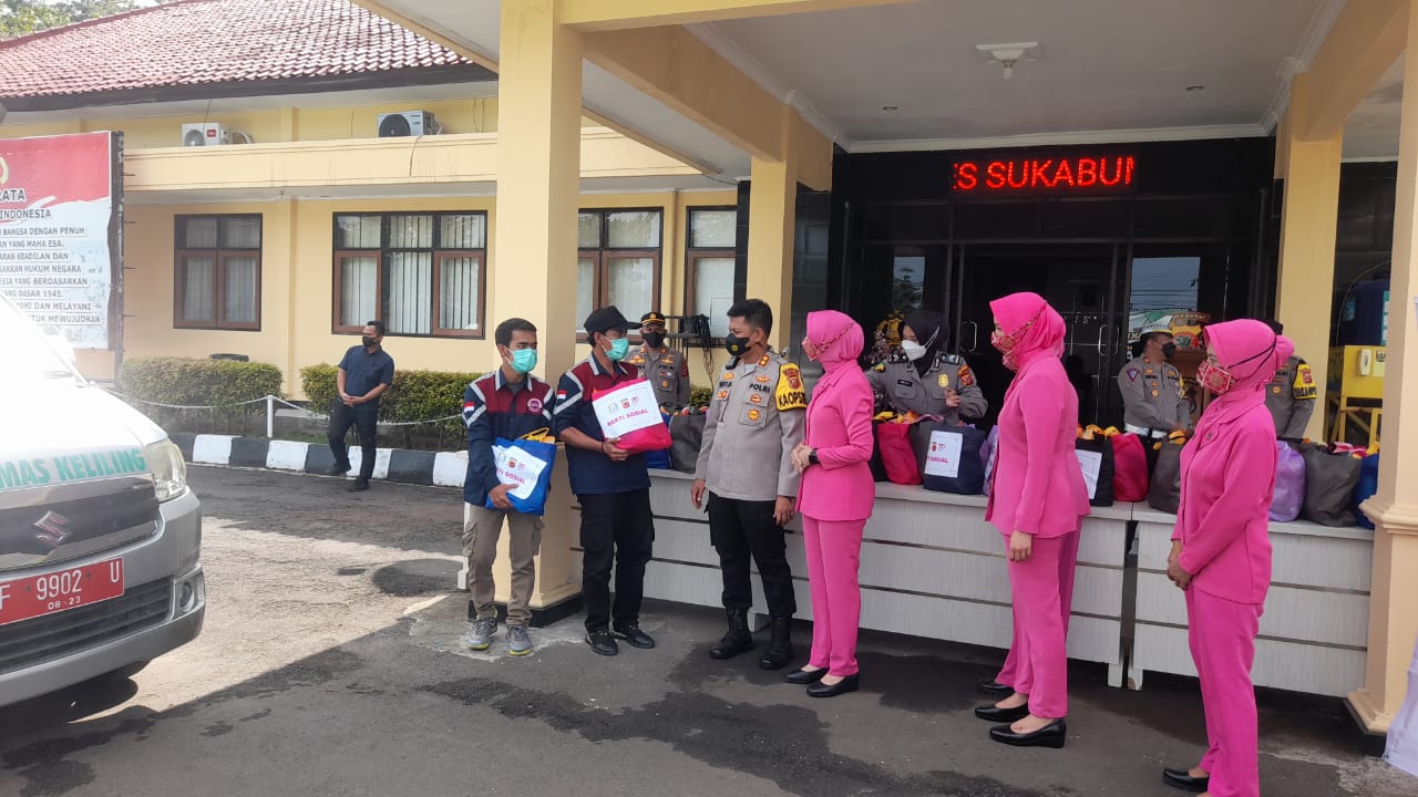 Kapolres Sukabumi AKBP Dedy Darmawansyah didampingi ketua Bhayangkara Ny. Hesty Dedy beserja jajaran saat memberikan paket sembako