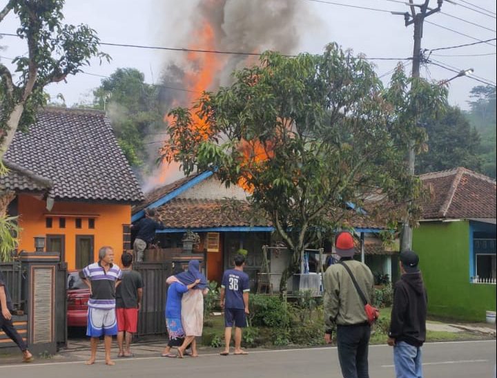 Warga saat berjibaku memadamkan api yang membakar tiga unit rumah warga di Kampung Cijangkar