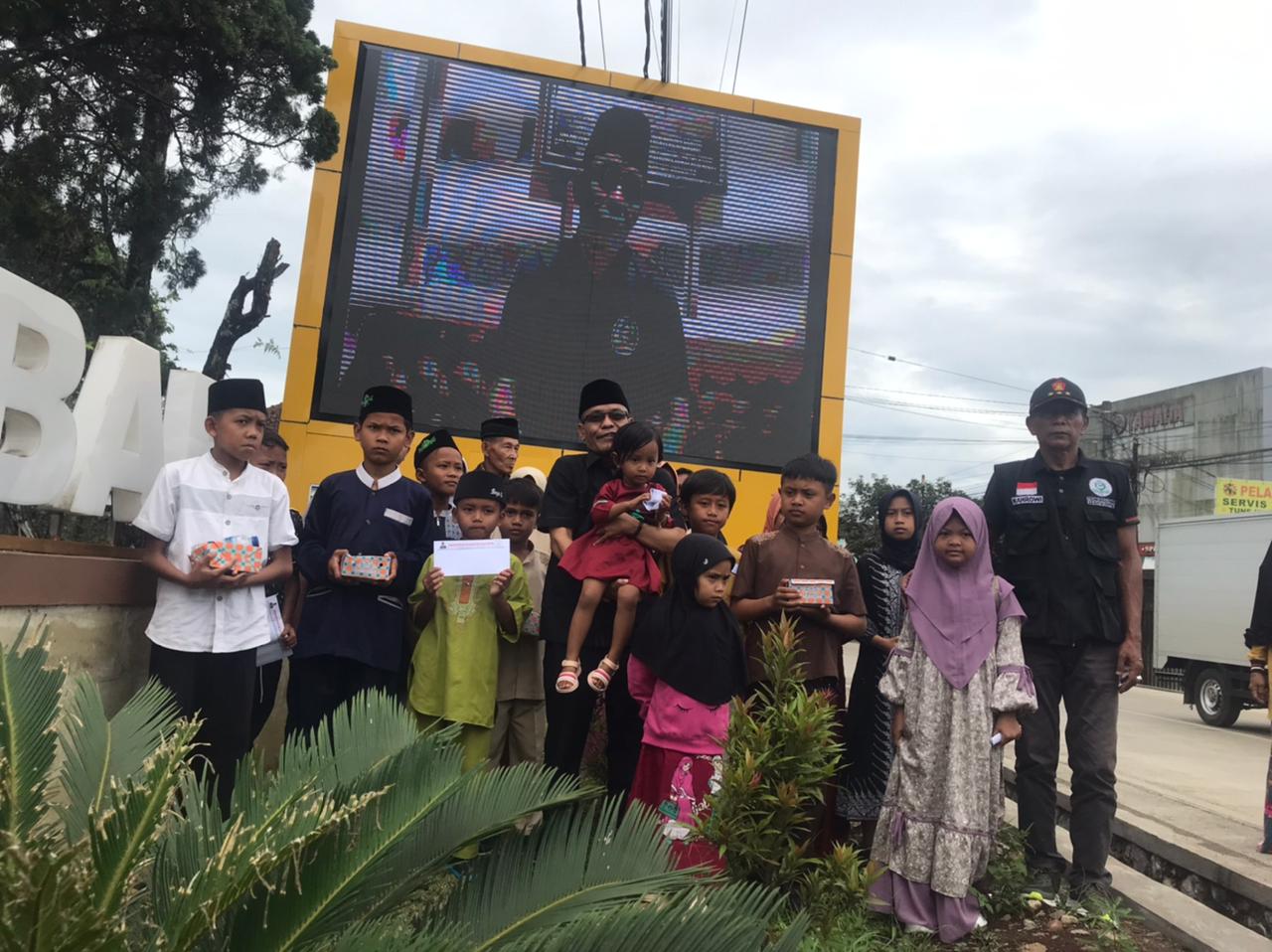 Anggota DPRD Kabupaten Sukabumi Fraksi Gerindra Ade Dasep Zaenal Abidin saat mengajak anak yatim berfoto bersama didepan Layar Videotron Murotal Alquran