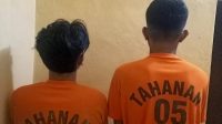 Dua terduga pelaku memakai saat memakai baju tahanan usai dirungkus Polsek Purabaya. 