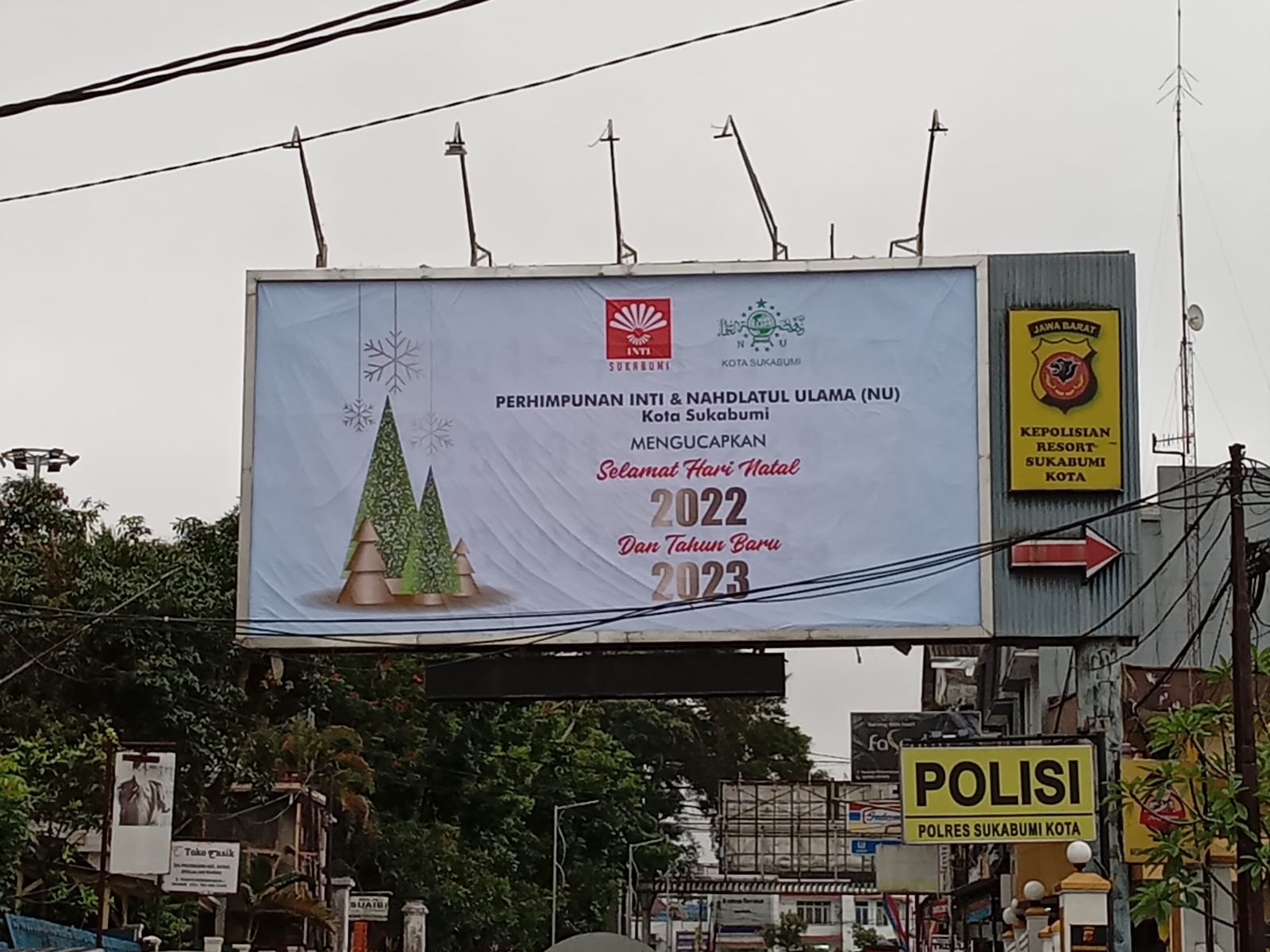 Billboard upacapan selamat natal dari komunitas INTI dan PC NU Kota Sulabumi terpampang di depan kantor Polres Sukabumi Kota