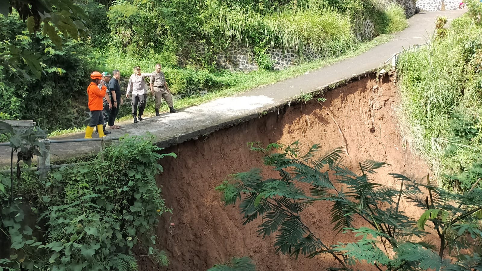 Polsek Parakansalak, saat memasang police line di lokasi jembatan ambruk penghubung