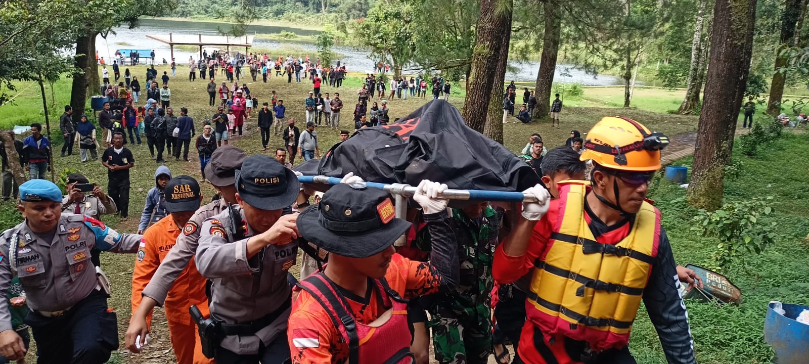 Petugas gabungan saat mengevakuasi salah satu korban yang tewas setelah tenggelam di kawasan Situ Gunung