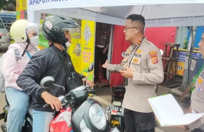 Petugas Kepolisian memberikan pelayanan kepada pemudik yang nyasar di Gunungputri, Kabupaten Bogor, Jawa Barat.