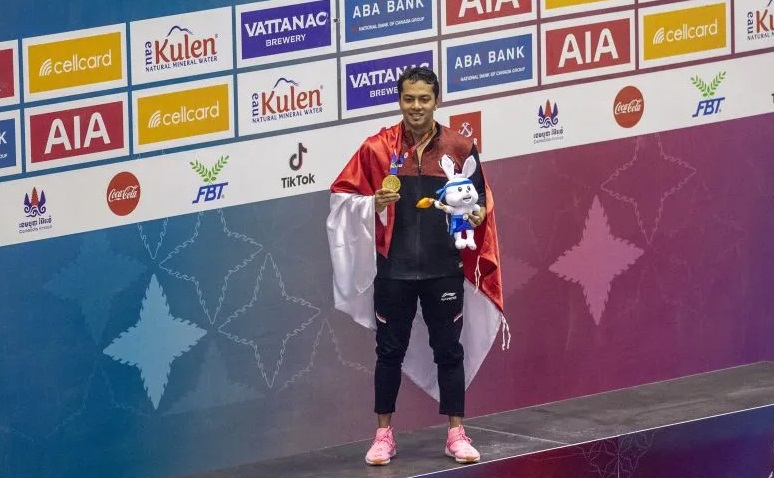 Perenang Indonesia I Gede Siman Sudartawa menunjukan medali seusai penyematan medali emas untuk nomor 50 meter gaya punggung putra saat SEA Games 2023 di Aquatics Center,