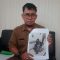 PRIHATIN : Petugas Pengelola Data Penempatan Tenaga Kerja pada Disnakertrans Kabupaten Sukabumi, Indra Santika, saat menunjukan foto Lia (33) PMI asal Jampangtengah yang disiram majikannya di Saudi Arabia.(FOTO : DENDI/|RADAR SUKABUMI)