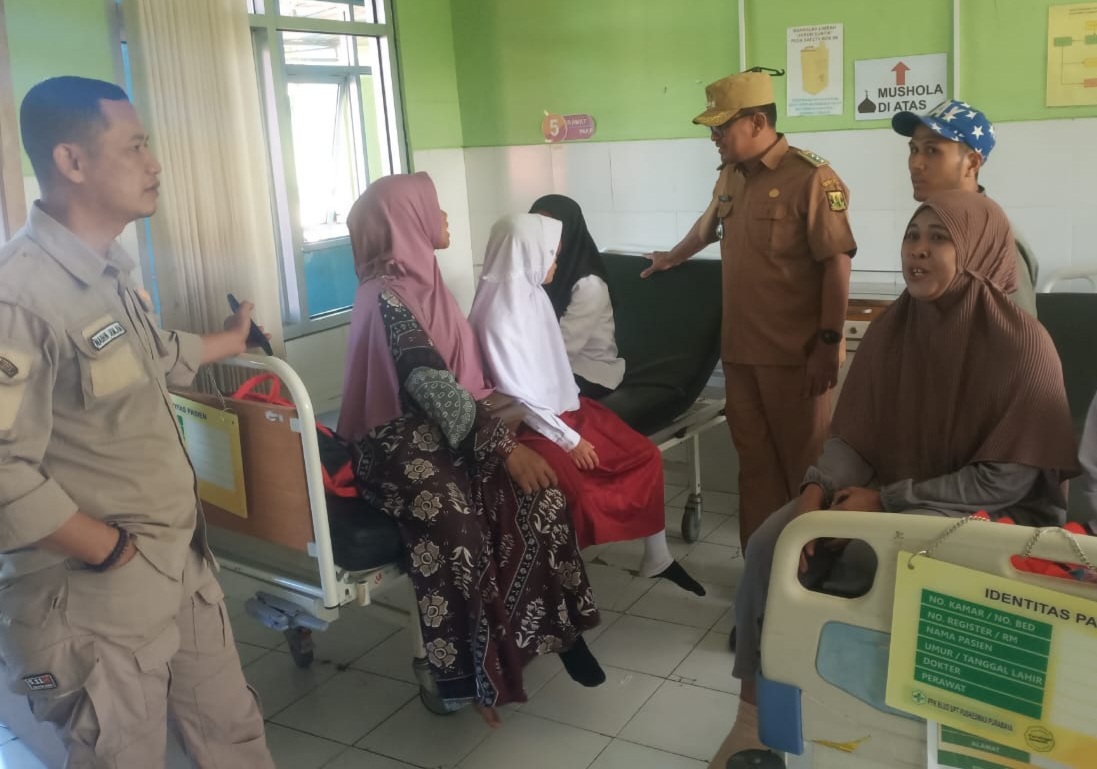 DITANGANI : Camat Purabaya, Mulyadi bersama jajaranya saat mengevakuasi sejumlah siswa yang mengalami keracunan jajanan samenan.(foto : ist)
