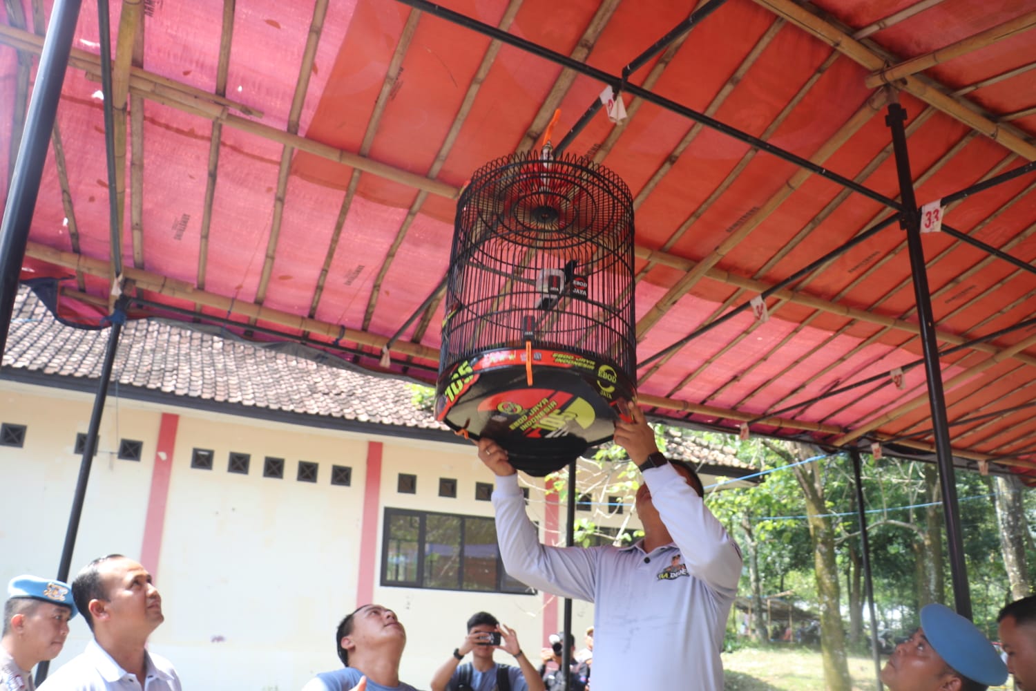 Kapolres Sukabumi AKBP Maruly Pardede saat menaikan sangkar burung dalam kompetisi burung berkicau, Minggu (18/6).(Foto : ist)