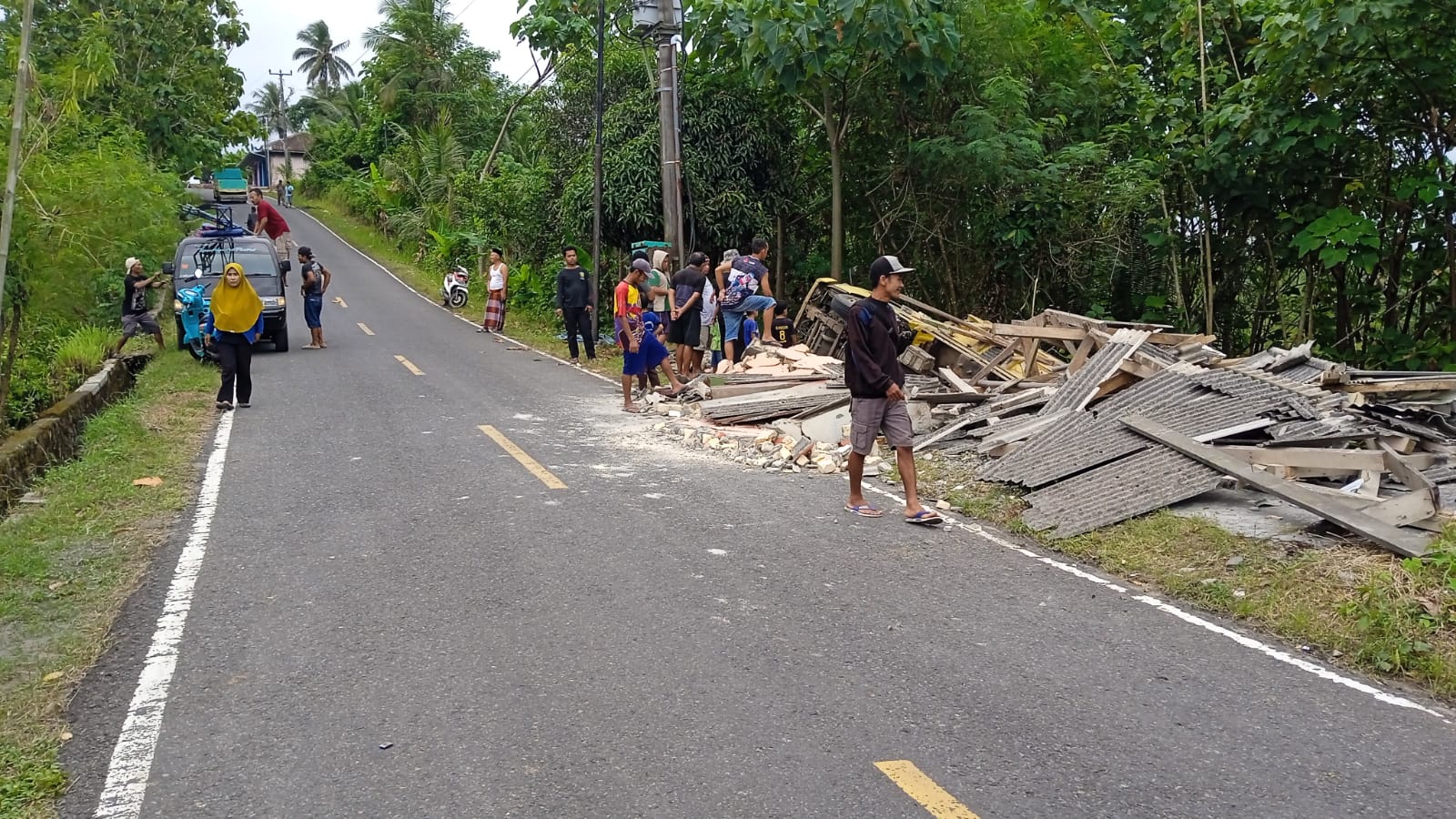 LAKALANTAS : Kondisi dump truk terguling dan menimpa rumah kosong milik warga di tanjakan puncak batu, Tegalbuleud Kabupaten Sukabumi.