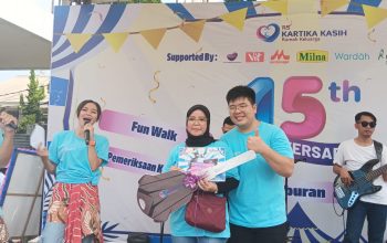 DOORPRIZE: Direktur RS Kartika Kasih Yusak secara simbolis menyerahkan hadiah utama sepeda motor listrik kepada salah seorang warga Cisaat, Enda Jubaedah, Minggu (23/7).(FT: BAMBANG/RADARSUKABUMI)