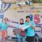 DOORPRIZE: Direktur RS Kartika Kasih Yusak secara simbolis menyerahkan hadiah utama sepeda motor listrik kepada salah seorang warga Cisaat, Enda Jubaedah, Minggu (23/7).(FT: BAMBANG/RADARSUKABUMI)