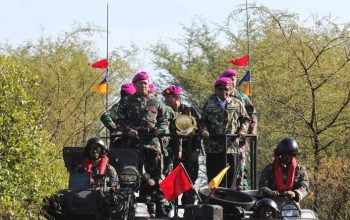 Panglima TNI Laksamana TNI Yudo Margono (kiri) bersama Menko Polhukam Mahfud MD (kanan) berdiri di atas tank amphibi saat upacara pengangkatan sebagai warga kehormatan Korps Marinir di Pantai Banongan, Situbondo, Jawa Timur, Selasa (1/8/2023).