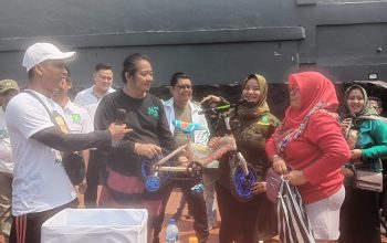 PEMBAGIAN SEPEDA: Salah seorang peserta jalan santai saat mendapatkan door prize sepeda di Halaman Gedung Juang 45, Jalan Veteran Kecamatan Cimole, Minggu (27/8).(FT: BAMBANG/RADARSUKABUMI)