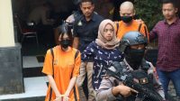Personel Polres Sukabumi Kota saat menggiring dua Youtuber sebagai tersangka kasus promosi judi online. (Antara)