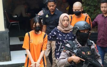 Personel Polres Sukabumi Kota saat menggiring dua Youtuber sebagai tersangka kasus promosi judi online. (Antara)