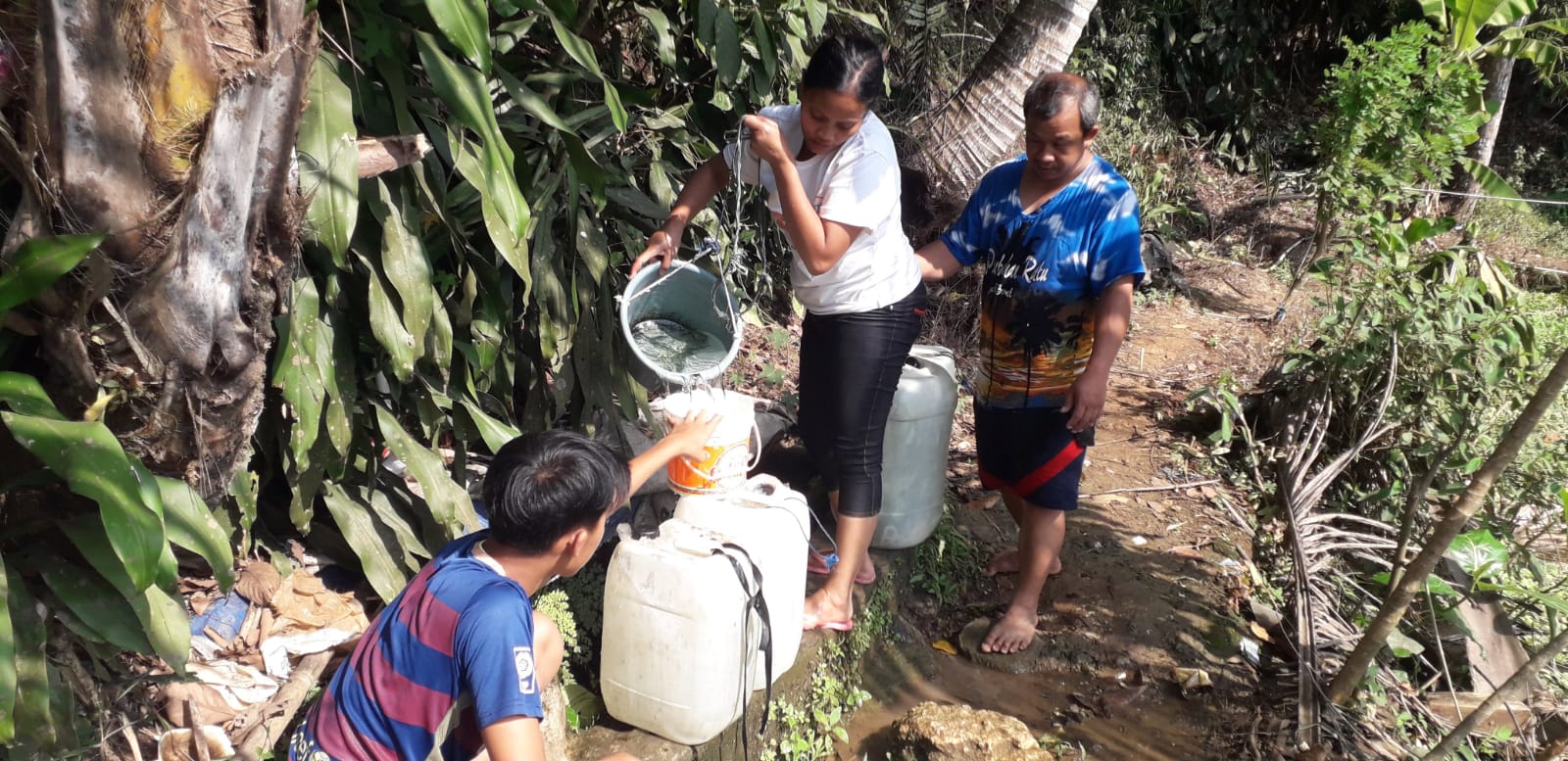 KEKERINGAN: Sejumlah warga Kampung Tanjakanlengka, Desa Parakanlima, Kecamatan Cikembar, Kabupaten Sukabumi, saat bergiliran mengambil air bersih dari mata air resapan pohon.(FOTO : DENDI/RADAR SUKABUMI)