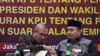 Ketua KPU RI Hasyim Asy'ari (kiri) menyalami anggota Komisioner KPU Mochammad Afifuddin (kanan) usai mengikuti uji publik rancangan peraturan KPU di Jakarta, Senin (4/9/2023). (RISYAL HIDAYAT)