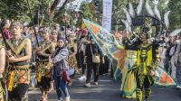 Gubernur Jawa Barat Ridwan Kamil (kanan) menyapa warga dengan menggunakan kostum saat mengikuti karnaval budaya West Java Festival di Bandung, Jawa Barat, Minggu (3/9/2023).