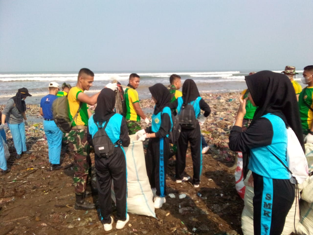 BERSIHKAN SAMPAH : Puluhan siswa SMK Yasipa Terpadu Palabuhanratu saat ikut melakukan pembersihan bersama TNI/Polri dan semua lapisan masyarakat di pantai Cibuntu Desa Loji Kecamatan Simpenan.