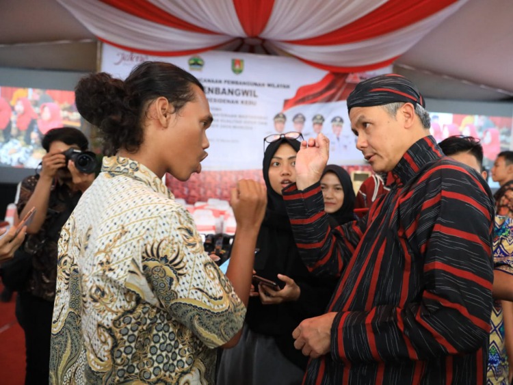 COBA MEMAHAMI: Ganjar Pranowo berbincang dengan Iqbal, penyandang tuna rungu asal Temanggung saat berada di Pendopo Kabupaten Magelang. (Foto: Humas Pemprov Jateng)