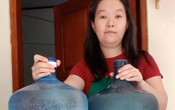 MENUNJUKAN : Wanita yang kelihatannya berdomisili di Bali tersebut, tampil dengan dua galon Aqua yang berbeda. Ada galon Aqua dengan kemasan yang lebih gelap, sementara galon Aqua lain kelihatan dengan warna yang lebih bening. (Tangkapan layar)