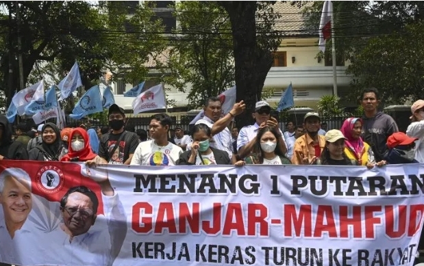 Sejumlah simpatisan membawa spanduk bergambar pasangan bakal calon presiden dari PDI Perjuangan (PDIP) Ganjar Pranowo dan bakal calon wakil presiden Mahfud MD saat acara pengumuman pendamping bacawapres Ganjar Pranowo pada Pilpres 2024 di Kantor DPP PDIP, Jakarta, Rabu (18/10/2023).