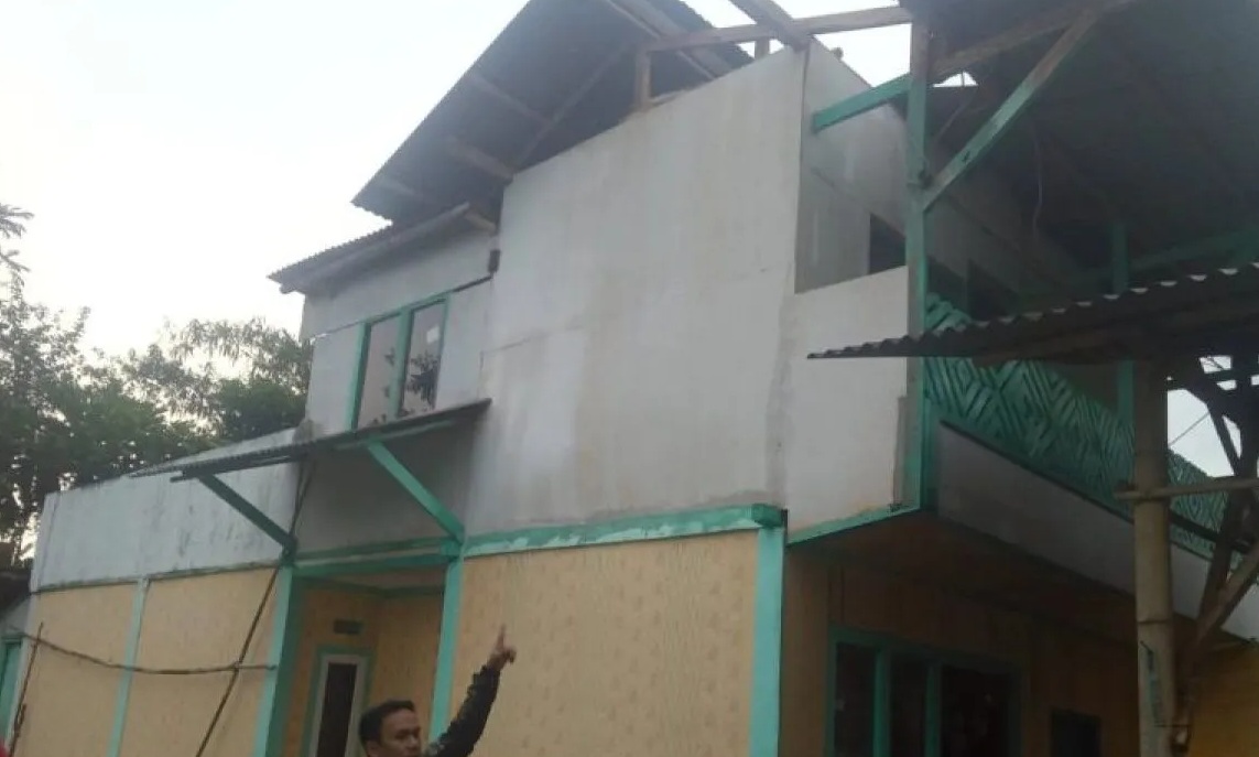 Salah seorang warga di Kampung Cisasah, RT 03/08, Desa Tugubandung, Kecamatan Kabandungan, Kabupaten Sukabumi, Jabar saat menunjukan bagian atap rumah yang rusak akibat diterjang angin puting beliung pada Rabu, (25/10).