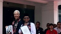 Pasangan bakal calon presiden dan bakal calon wakil presiden Ganjar Pranowo-Mahfud MD menyapa awak media di pelataran Kantor KPU RI, Jakarta, Kamis (19/10/2023). (Genta Tenri Mawangi)