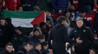 Penggemar Manchester United mengibarkan bendera Palestina di akhir pertandingan Piala Liga Inggris antara Manchester United kontra Newcastle United di Old Trafford, Manchester, Rabu (1/10/2023).(Action Images via Reuters/Lee Smith)