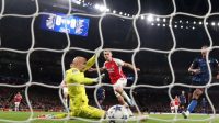 Pemain Arsenal Leandro Trossard mencetak gol pertama setelah mengecoh kiper Sevilla Marko Dmitrovic dalam pertandingan Liga Champions Grup B di Stadion Emirates, London, Inggris, Rabu (8/10/2023). (Reuters/Peter Cziborra)