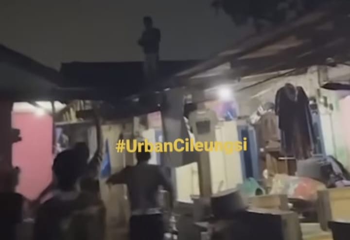 Petugas dibantu warga mengepung pria yang lari keatas genting rumah di Kalpanunggal, Kabupaten Bogor. Foto : Tangkapan layar Urbancileungsi