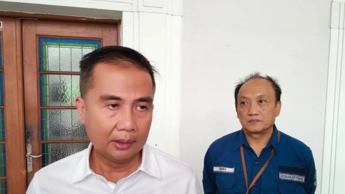 Penjabat (Pj) Gubernur Jawa Barat Bey Triadi Machmudin didampingi Kepala Dinas Tenaga Kerja dan Transmigrasi (Disnakertrans) Jawa Barat Teppy Wawan Dharmawan (kanan) memberikan keterangan di Gedung Sate Bandung, Selasa (14/11/2023). (Ricky Prayoga)