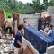 GOTONG ROYONG: Warga dan petugas gabungan saat gotong royong membersihkan material bangunan rumah yang rusak akibat disapu puting beliung.
