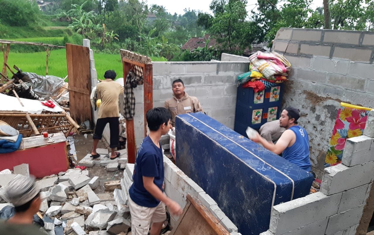 GOTONG ROYONG: Warga dan petugas gabungan saat gotong royong membersihkan material bangunan rumah yang rusak akibat disapu puting beliung.