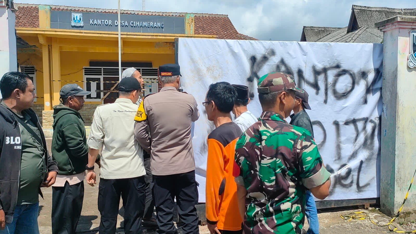DIBUKA : Sejumlah warga yang disaksikan aparat setempat pada saat membuka penyegelan kantor Desa Cihamerang.(foto :ist)