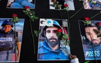 Warga menaruh bunga mawar di atas sejumlah foto jurnalis peliput konflik Israel di Gaza, Palestina pada aksi damai di Solo, Jawa Tengah, Minggu (17/12/2023). (Maulana Surya)