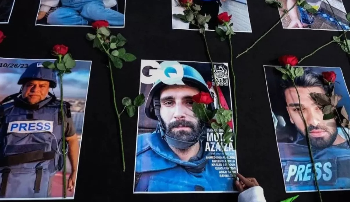Warga menaruh bunga mawar di atas sejumlah foto jurnalis peliput konflik Israel di Gaza, Palestina pada aksi damai di Solo, Jawa Tengah, Minggu (17/12/2023). (Maulana Surya)