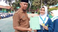 BANGGA: Kepala SMPN 13 Kota Sukabumi, Asep Fajar Anshari saat memberikan ucapan selamat kepada siswa yang berprestasi pada kejuaraan Karate Tingkat Internasioal di sela-sela upacara bendera di sekolah. (dok/radarsukabumi )