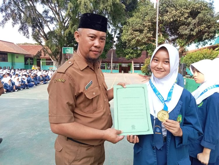 BANGGA: Kepala SMPN 13 Kota Sukabumi, Asep Fajar Anshari saat memberikan ucapan selamat kepada siswa yang berprestasi pada kejuaraan Karate Tingkat Internasioal di sela-sela upacara bendera di sekolah. (dok/radarsukabumi )
