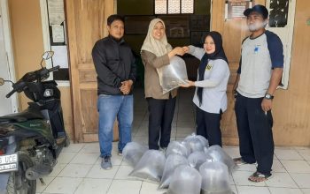 Perangkat Dinas Perikanan Kabupaten Sukabumi saat menyerahkan benih ikan Nilem kepada kepala desa.(foto : ist)